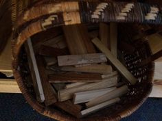 a basket full of wood sticks sitting on the floor