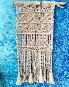 a wall hanging made out of macrame and rope with tassels on it