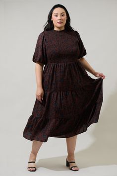 The Kalida Beau Frazier Smocked Tiered Midi Dress is reminding us of all the reasons to feel gratitude. Full, short puff sleeves frame a flattering smocked bodice that tops a flowy, tiered midi skirt. A keyhole sits at the top of the back to make getting in and out easier. Wear it to any event with your favorite accessories and boots to complement the look.- Smocked- Keyhole- Tiered- Bubble sleeves- Color: ChocolateSize + Fit - Model is 5'9" and wearing size 2X- Measurements taken from size 2X - Modest Smocked Ruched Short Sleeve Dress, Fall Smocked Dress With Short Sleeves, Flowy Brown Smocked Dress With Smocked Bodice, Flowy Smocked Dress With Short Sleeves And Smocked Cuffs, Billowy Smocked Dress With Short Sleeves, Brown Dress With Smocked Bodice And Short Sleeves, Brown Short Sleeve Dress With Smocked Bodice, Brown Smocked Bodice Dress, Midi Length, Brown Smocked Midi Dress