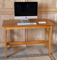 an apple computer sitting on top of a wooden desk