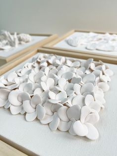 some white flowers sitting on top of a table next to other pieces of art work