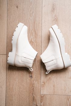 The Zari Boot is a sleek, minimalist ankle boot designed with modern functionality and effortless style in mind. Featuring a smooth, off-white faux leather finish and a chunky lug sole for added traction and comfort, these boots are perfect for everyday wear. Slip-on design with elastic side panels ensures easy on-and-off convenience, making them ideal for the woman on the go. Closure: slip-on Toe Shape: almond Heel Height: 2 inches Platform Height: 1.5 inches Boot Shaft: 4 inches Materials: fau Modern White Boots With Lug Sole, Spring Ankle-high Chelsea Boots With Lug Sole, Trendy Cream Boots With Lug Sole, Spring Ankle Moto Boots With Lug Sole, Fall Cream Boots With Lug Sole, Trendy Beige Platform Boots With Lug Sole, Trendy Cream Ankle Platform Boots, Chic Cream Boots With Lug Sole, Modern Platform Ankle Boots With Lug Sole