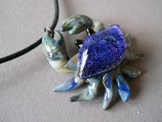 a blue and white necklace with an animal on it's back end, sitting on top of a table