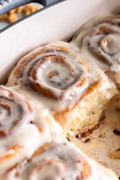 cinnamon rolls with icing in a white casserole dish