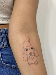 a woman's arm with a small dog tattoo on it