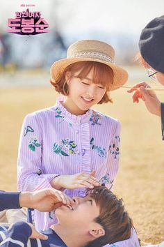 two people are sitting on the ground and one is feeding another person something with his hand