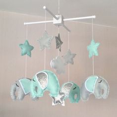 a baby crib mobile with elephants and stars hanging from it