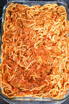 a casserole dish filled with spaghetti and meat sauce