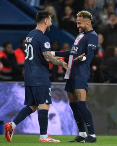 two soccer players are shaking hands on the field