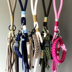 several different colored lanyards hanging from hooks on a gray wall with white walls in the background