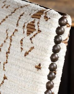 a close up view of a rug with beads on it's end and the fabric