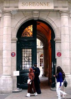 two people walking in front of an entrance to a building that says sorbone