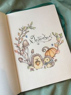 an open notebook with the words hello november written on it and two hedges holding pumpkins