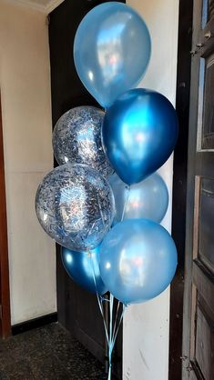 a bunch of blue balloons sitting on top of each other in front of a door