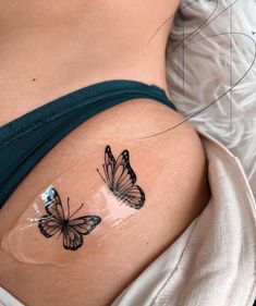 two butterflies on the side of a woman's stomach, one is black and white