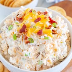 a white bowl filled with potato salad next to crackers