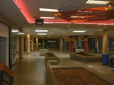 an empty lobby with benches and lights on the ceiling, in front of a sign that reads media play