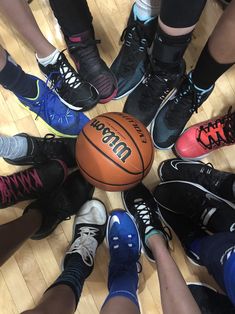 a group of people standing around a basketball