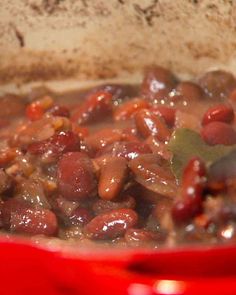 a red pot filled with beans and meat