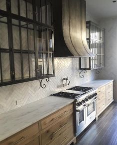 a kitchen with wooden cabinets and white marble counter tops, an oven top and range hood