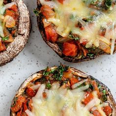 three stuffed mushrooms covered in cheese and vegetables