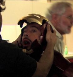 a man wearing a helmet talking on the phone while another man looks at his cellphone