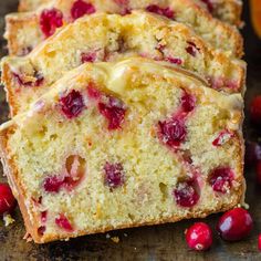 cranberry orange bread with icing and fresh cherries on the side, ready to be eaten