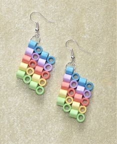 a pair of earrings made out of colored paper