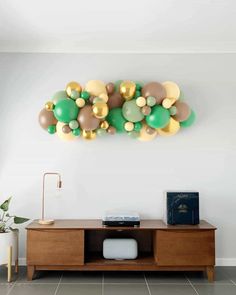 balloons are hanging on the wall above a wooden entertainment center in this modern living room