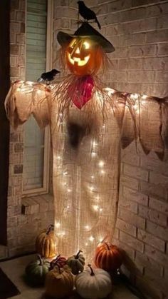 a lighted scarecrow standing in front of a brick wall