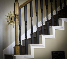 a clock on the side of a stair case next to a banister and railing