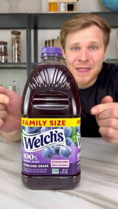 a man sitting at a table in front of a bottle of weight's blueberry juice