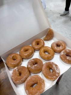 a box full of glazed donuts on a table