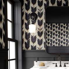 a bathroom with black and white wallpaper, two sinks and a mirror on the wall