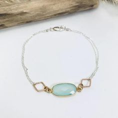 A large oval cut of blue-green chalcedony is the star of this lightweight bracelet. It is accented with tiny hand forged gold filled diamond shapes which shimmer with the stone and is finished with fine sterling silver chains. From our Skylight Collection. #crystalbracelet #chalcedony #mixedmetals •14k gold filled and sterling silver •Chalcedony •7.25" Wire Jewelry Patterns, Green Chalcedony, Silver Chains, Tiny Hand, Jewelry Repair, Jewelry Patterns, Hand Forged, Crystal Bracelets, Semi Precious Gemstones