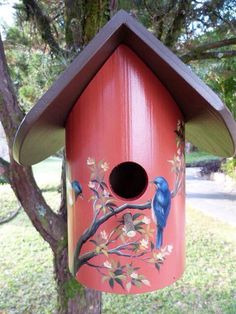 a red birdhouse with blue birds painted on it