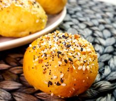 two buns with sesame seeds sit on a plate