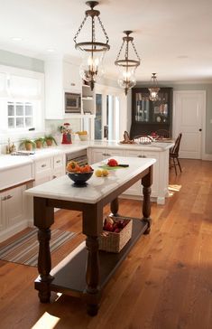 a large kitchen with an island in the middle and lots of counter space on one side