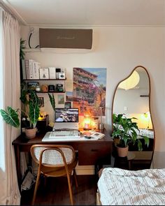 a bedroom with a desk, mirror and plants