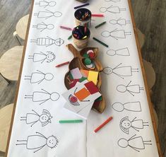 a table topped with lots of crafting supplies on top of a white paper covered table