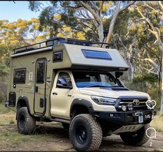 a truck with a camper attached to it parked in the woods