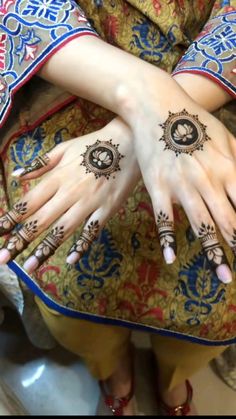 a woman's hands with henna tattoos on them