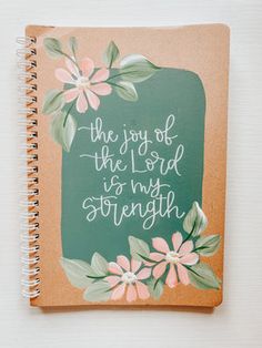 the joy of the lord is my strength journal with pink flowers and green background on top