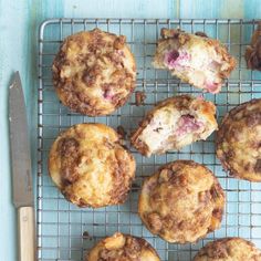 several muffins on a cooling rack with a knife