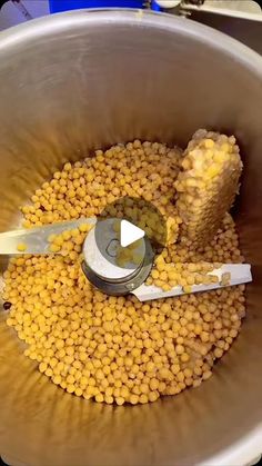 a metal bowl filled with yellow food next to a pair of scissors