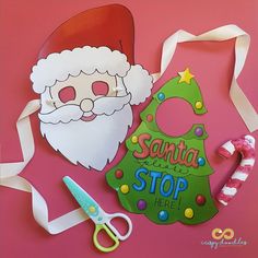 paper cut out of santa claus and christmas tree with scissors, candy canes and other items