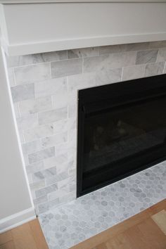 a fireplace with white marble and hexagonal tile