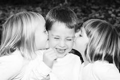 three young children are kissing each other in black and white