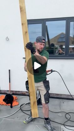 a man is using a power drill on a wooden pole