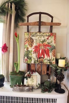 a christmas mantle with plants and candles on it